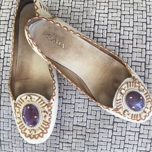 Prada moccasin white flats with purple stone trim.